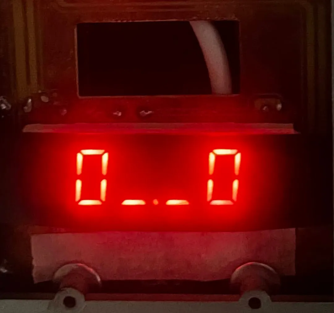 The finished device: red seven-segment digits glowing in a dark enclosure